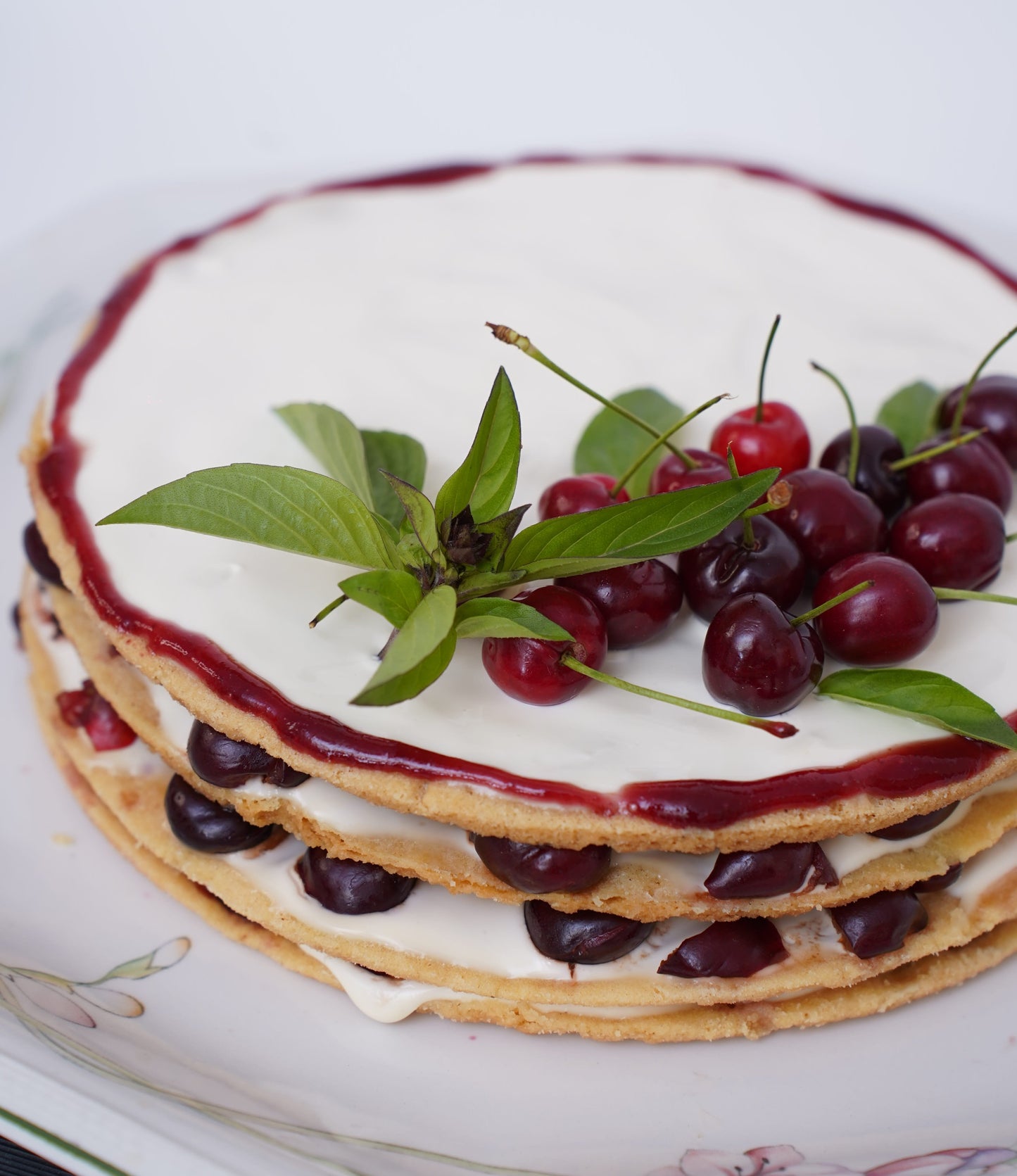 Cherry Shortbread Dessert: Layers of buttery shortbread biscuit, lathered with fresh cream and juicy cherries, topped with a beautifully arranged cherry layer and a delicate caramel web. Served with a box of homemade custard for an extra touch of indulgence.