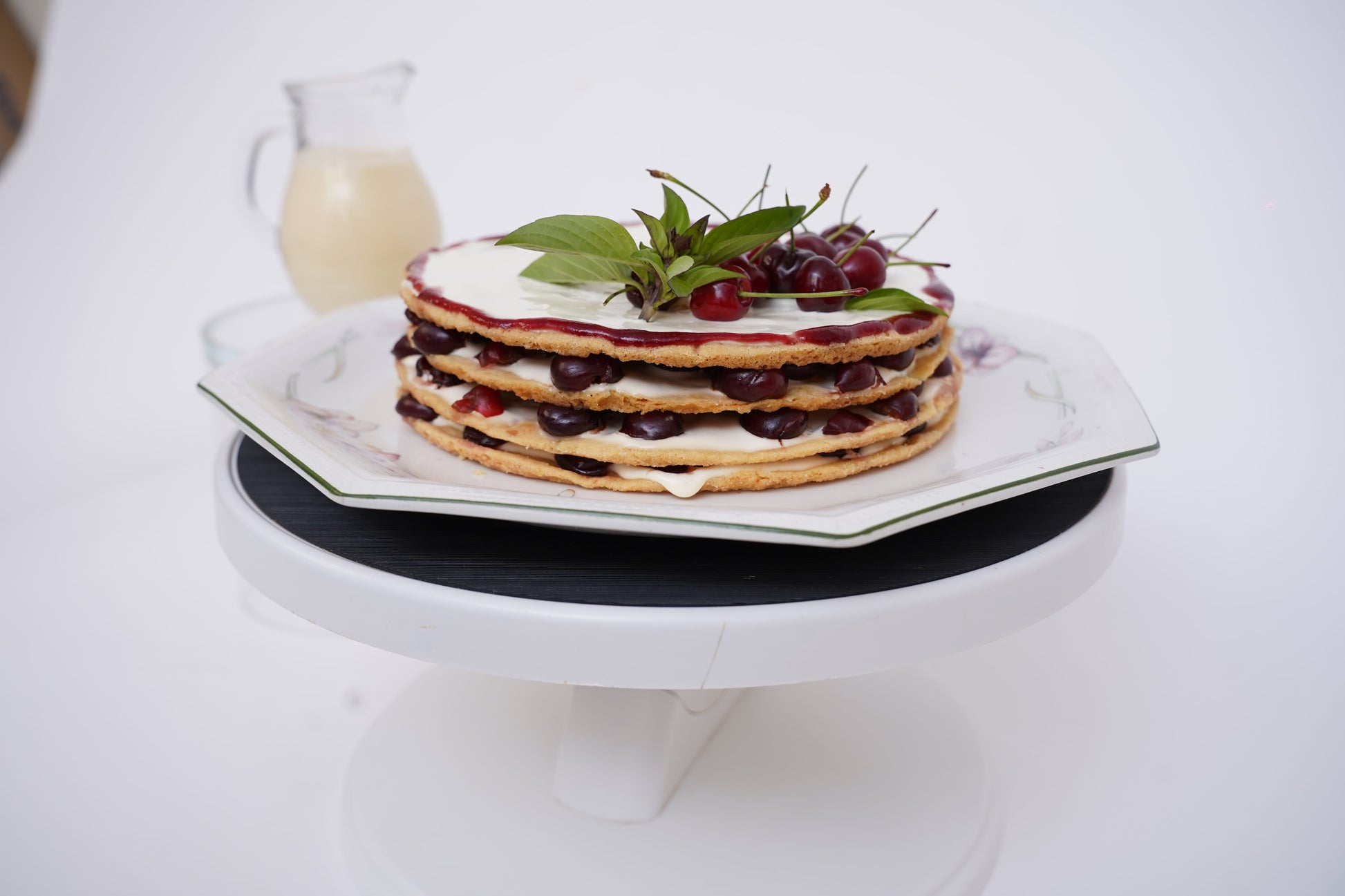 Cherry Shortbread Dessert: Layers of buttery shortbread biscuit, lathered with fresh cream and juicy cherries, topped with a beautifully arranged cherry layer and a delicate caramel web. Served with a box of homemade custard for an extra touch of indulgence.